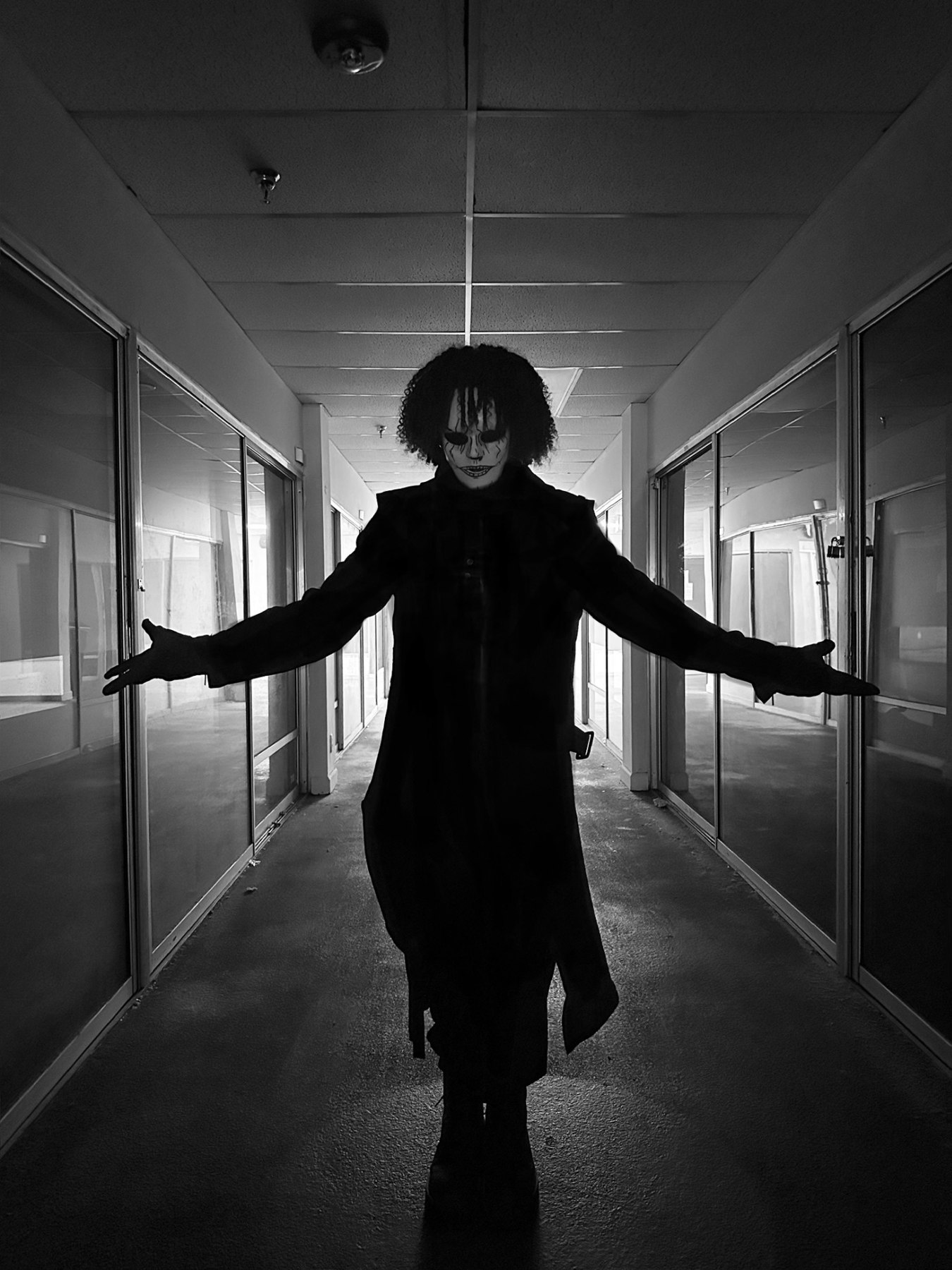 Phantomix with arms outstretched in a corridor